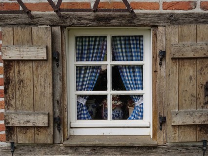 Rustic window with blue and white chequered curtains in a wooden frame, weseke, münsterland,