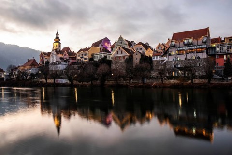 Christmas illuminated house facade of Frohnleiten reflected in the river Mur, Frohnleiten, Styria,