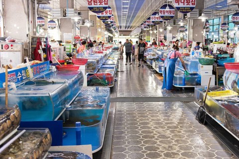Indoor fish market in Yeosu, South Korea with living fish and people shopping, Yeosu, South Korea,