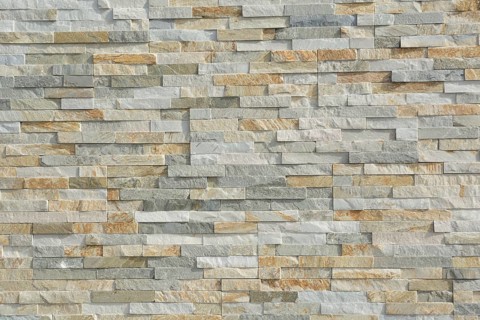 Thin natural stones form a pattern in a stone wall