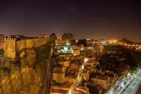 Night view of Porto funicular railway, house roofs with illumination