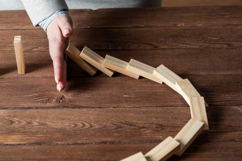 Business woman block domino effect. Business assistance, risk management and stabilisation