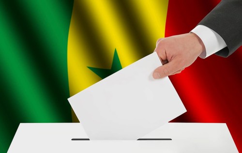 The Senegal flag and the hand with the bulletin about the ballot box