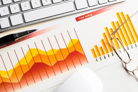 Business workplace with keyboard mouse and papers with graphs and diagrams