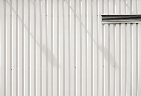 A modern façade of a shopping centre and DIY store made of checker plate with a ventilation slot