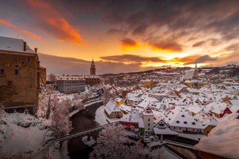 Winter view of Cesky Krumlov, picturesque houses under the castle with snow-covered roofs. Narrow
