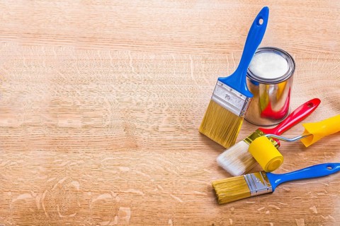 Organized copyspace set of paint brushes roller and can on wooden board