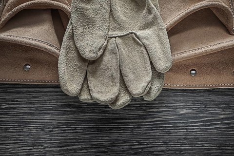 Tool belt safety gloves on wooden board