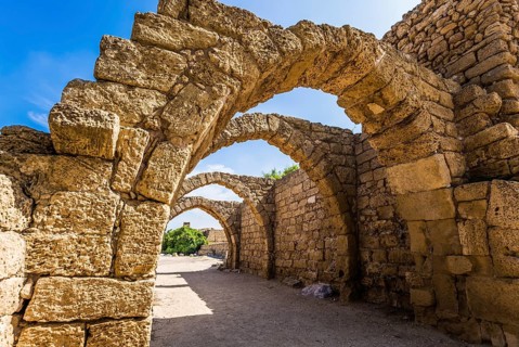 Picturesque ruins of the ancient city of Caesarea. Israel. Sunny spring day. Arched passage -
