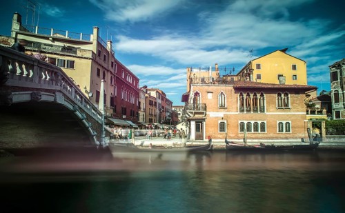 Ancient buildings and boats in the channel in Venice