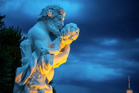 Marble statue of a man holding a small child at the castle in Karlsruhe beautiful lightened in the