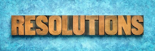 Resolutions word abstract in vintage letterpress wood type blocks against blue textured bark paper,