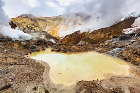 Lake in crater of active volcano. Beautiful dramatic volcanic landscape: hot spring, fumarole,