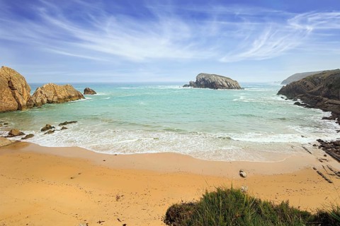 Playa de la Arnia beach. Amazing geological formations amaze tourists. Sea waves break on the