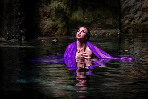 A beautiful nude latin model enjoys the gorgeous water in a colorful cenotes in Yucatan Merida,