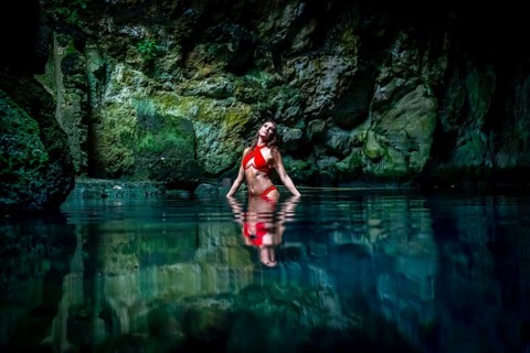 In Cuzama, Yucatan, Mexico, a stunning model revels in the vibrant hues of a cenote's blue and