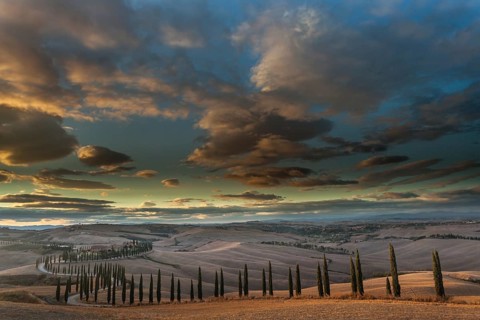 Tuscan hilly landscape with cypresses under a dramatic sky, Asciano, Province of Siena, Tuscany,