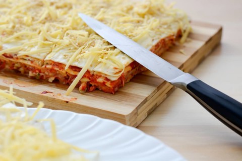 Salt cake with cheese and red paprika on wooden table with knife
