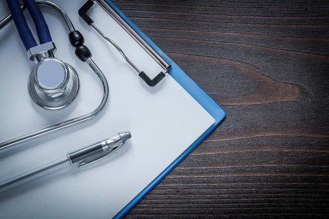 Clip board pen and stethoscope tablet on vintage wooden background medicine concept
