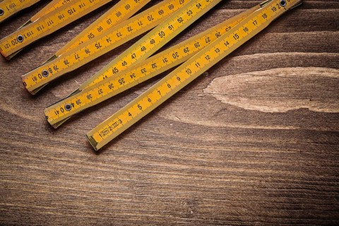 Yellow wooden meter on wood board top view construction concept