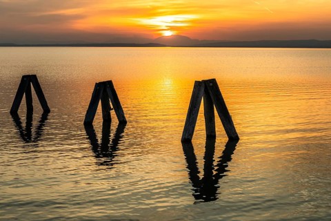 Evening atmosphere at the lake at sunset, bollard in Lake Neusiedl, Podersdorf, Burgenland,