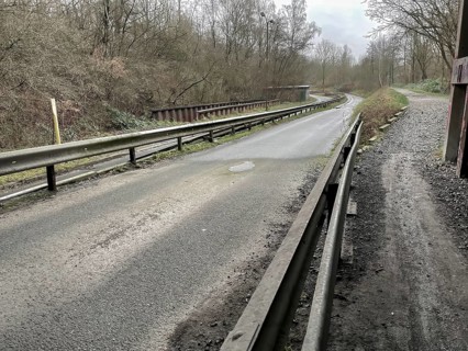 Unused industrial road in poor condition in the rain