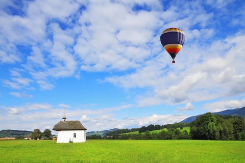 A balloon flies over the charming white village chapel. Southern France