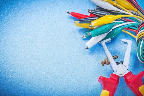 Cable crocodiles insulation strippers on blue background electricity concept