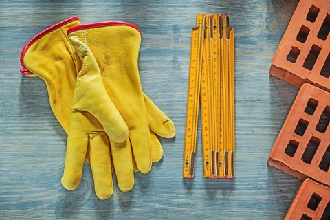 Leather safety gloves red bricks wooden meter on wood board bricklaying concept