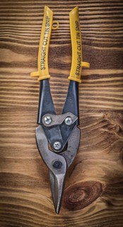 Sharp metal steel cutter on vintage wooden board construction concept