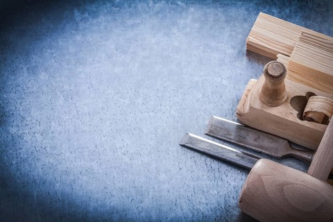 Wooden planer hammer bricks firmer chisels on metallic background copyspace