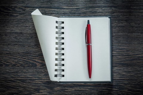 Spiral blank notebook ballpoint pen on vintage wooden board