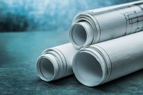 Rolls of blueprints on metalic background