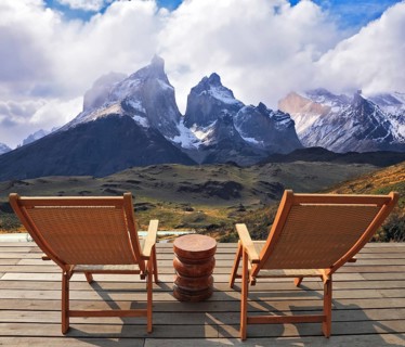 Comfortable lounge chairs on wooden platform for rest and observation. Gorgeous snow-covered rocks