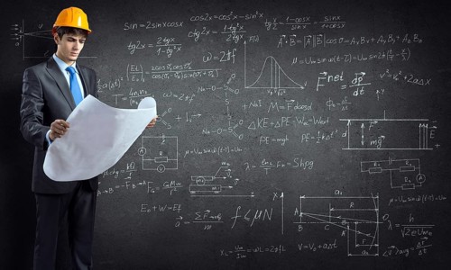 Young thoughtful man engineer in helmet with project in hands and sketches on wall
