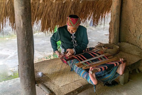 Old woman sew in traditional tribal dress
