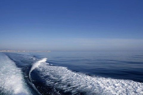 Blue sea ocean with boat wake, prop wash foam