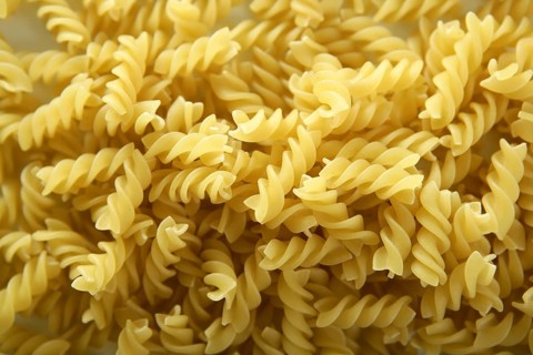 Close-up of italian spiral yellow pasta texture as background