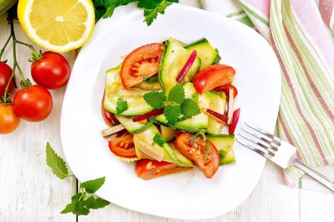 Salad of young zucchini, radish, tomato and mint, seasoned with lemon juice and soy sauce in a