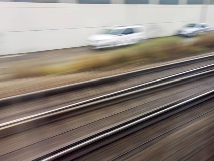 Tracks and rails in motion from a moving train. Symbolic photo for train journey, speed and