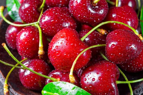 Freshly picked cherry in a wooden bowl