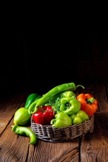 Various harvested peppers and hot peppers in basket