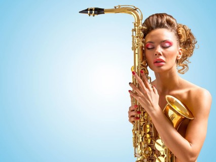 Retro photo of a sleepy naked pin up woman with closed vintage winged eyes embracing a saxophone