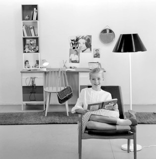 In the 1960s. A teenage girl in her typical 1960s room, a desk and her things with pictures of her