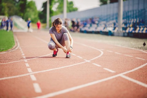 Theme sports and sportswear. A young Caucasian woman in uniform lacing shoelaces adjusting shoes