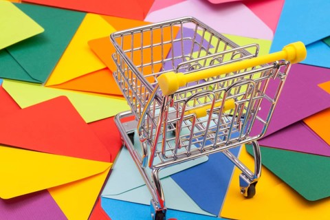 Shopping trolley and different colored envelopes on the table