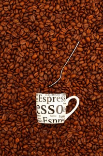 Cup of coffee on a table full of coffee beans. Coffee design