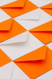 Composition with white and orange envelopes on the table