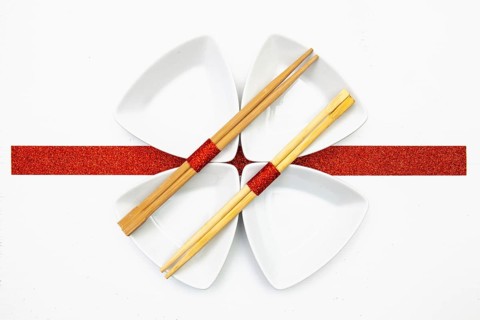 Ceramic bowls and bamboo chopsticks for sushi food with red and white decoration