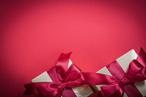 Wrapped present boxes on red background top view holidays concept